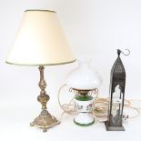 A modern pierced metal candle stand, an oil lamp converted to electric, and another brass table lamp