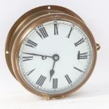 A brass ship's bulkhead clock, white dial with Roman numeral hour markers, dial diameter 15.5cm