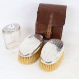 A cased pair of silver-backed brushes, and a silver-topped dressing table jar (3)