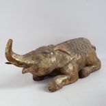 A large and heavy lacquered and gilded hardwood recumbent caparisoned elephant sculpture/foot