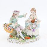 A German Sitzendorf porcelain group, seated couple with flowers, crowned S mark on base, height 14cm