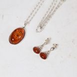 A matching silver-mounted amber pendant necklace and earring set