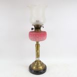 A brass and pink opalescent glass oil lamp, with etched glass shade, overall height including