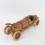 A handmade carved wood model sculpture of a Veteran racing car, by Clive Fredriksson, length 39.5cm