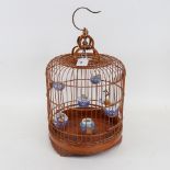 An Oriental stained bentwood birdcage with porcelain feeder bowls, height 40cm