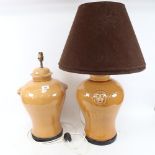 A large pair of Oriental style caramel glaze baluster jar table lamps and shades, with lion mask