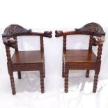 A pair of stained pine and beech bow-arm corner chairs, with carved decoration and dragon arms