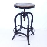 A revolving machinist/workroom stool on scrolled iron base