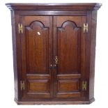 A Georgian oak hanging corner cupboard, with 2 arch-top fielded panel doors, W82cm, H91cm