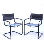 A pair of contemporary style tubular black metal cantilever armchairs