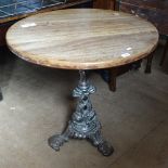 A circular hardwood-top garden table on cast-metal dolphin design base, W76cm, H75cm