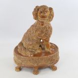 A large 19th century salt glaze stoneware seated Spaniel wearing a padlocked collar, seated on an