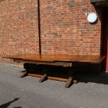 A large Maple & Co oak extending refectory dining table, with relief carved geometric frieze, raised