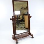 A Victorian mahogany-framed cheval mirror, with melon carved finials, reeded supports and