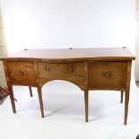 A George III mahogany serpentine-front sideboard, with brass-railed back, central frieze drawer