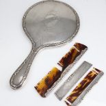 A silver-backed dressing table hand mirror, and 2 silver-mounted combs, mirror length 28cm (3) Lot