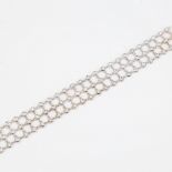 A modern 18ct white gold diamond triple-line bracelet, set with modern round brilliant-cut diamonds,