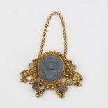 A Victorian unmarked gold lava cameo pendant, relief carved panel depicting Classical female bust