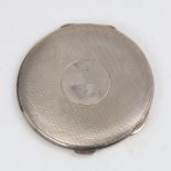 A George V Art Deco circular silver compact, allover engine turned decoration with engraved emblem