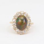 An early 20th century 18ct gold black opal and diamond cluster ring, set with oval high cabochon