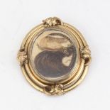 A large Victorian oval swivel mourning brooch, unmarked yellow metal frame with hair and braid panel