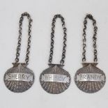 A set of 3 Elizabeth II cast-silver shell spirit decanter labels, comprising Whisky, Brandy and