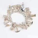 A late 20th century heavy sterling silver flat curb link charm bracelet, with heart padlock and