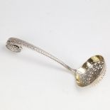 A Victorian silver-gilt sugar sifter spoon, allover ornate floral designs with pierced bowl, by