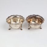 A pair of Edwardian silver salt cellars, circular form with scalloped rim on 3 feet, by Robert