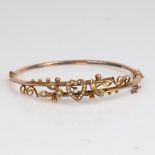 An early 20th century 9ct gold split-pearl heart and floral hinged bangle, hallmarks Chester 1905,