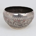 An early 20th century large Burmese silver rice bowl, relief embossed lion hunting and village