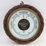 Aneroid barometer in carved oak frame, 27cm across