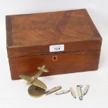 A mahogany box containing miniature fruit knives, and a brass Spitfire ornament