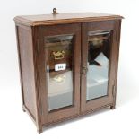 An oak table-top cabinet, with bevel-glass doors and drawer-fitted interior, 37cm