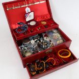 A red cantilever jewellery box, containing mixed costume jewellery, pocket watches, commemorative