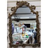 An ornate wall mirror, in scrolled floral frame, height 79cm