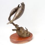 A bronze sculpture titled Manatee Remnant, depicting a manatee, terrapin and fish on a rock, on