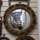 A large circular foliate gilt framed convex wall mirror, overall diameter 57cm