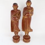 A graduated pair of lacquered and gilded Oriental monk figures, largest height 60cm