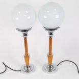 A pair of Art Deco style chrome and composition table lamps, with milk glass shades, overall