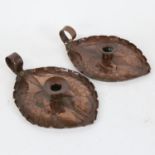 A pair of Arts and Crafts copper chambersticks, relief embossed fish decoration with strapwork