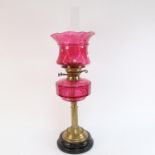 A Victorian cranberry glass and brass-mounted oil lamp, with cranberry shade, overall height 64cm (