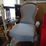 A Victorian walnut-framed open-arm fireside chair