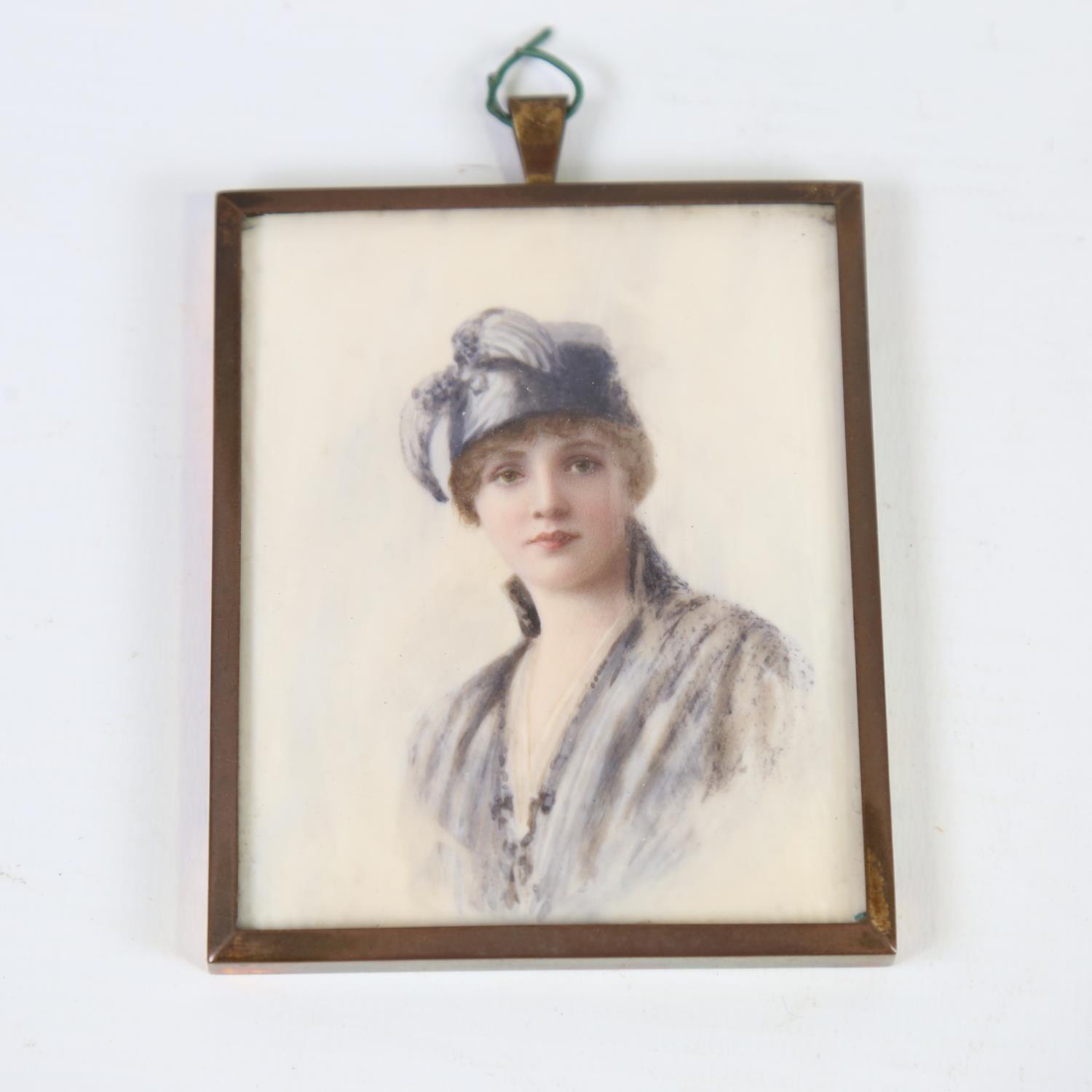 A miniature watercolour on ivory, portrait of a woman, circa 1920, unsigned, brass frame, overall