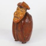 An 18th century coquilla nut snuffbox, in the form of a man wearing a long coat, length 8.5cm