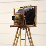 A mahogany and brass plate camera, circa 1900, the brass lens inscribed Dollond London Rapid