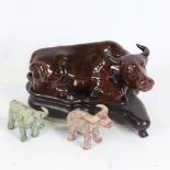 A Chinese brown treacle glaze pottery buffalo on hardwood stand, length 21cm, and 2 miniature