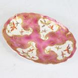 An oval porcelain dish, 18th or 19th century, hand painted and gilded bird decorated panels, with