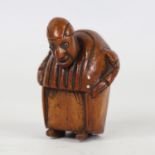 An 18th century coquilla nut snuffbox, in the form of a man wearing a long coat, length 6.5cm