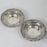 A pair of early 20th century silver bon bon baskets, relief embossed floral border with pierced